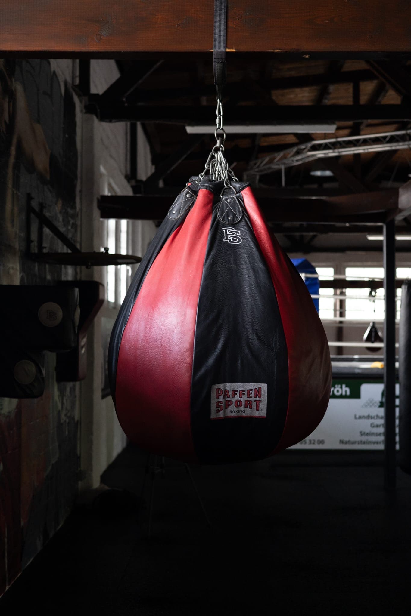 Speedball aus rotem und schwarzem Leder, im Hintergrund der Ring